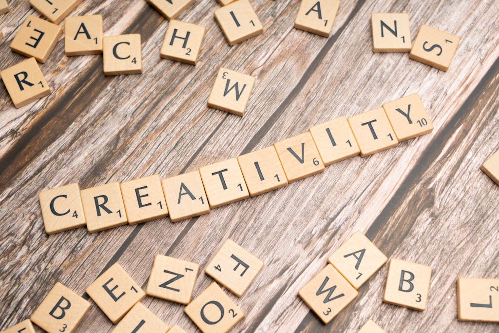 Wooden letter tiles spelling 'creativity' on a rustic wooden background.